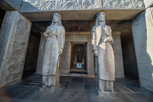 Lovcen National park,Montenegro-September 14 2019:On the summit of Mount Jezerski Vrh,two tall statues guard the entrance to themonument and tomb of Petar Petrovic-Njegos II,in the summer sun.