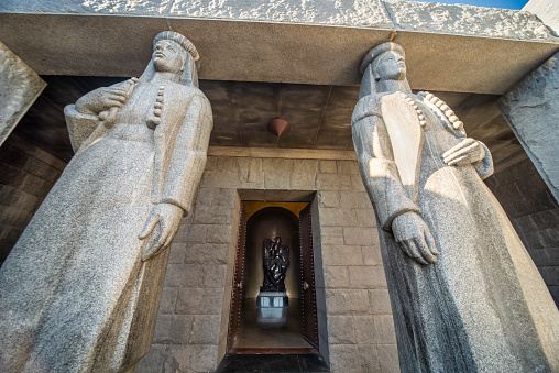 Lovcen National park,Montenegro-September 14 2019:On the summit of Mount Jezerski Vrh,two tall statues guard the entrance to themonument and tomb of Petar Petrovic-Njegos II,in the summer sun.