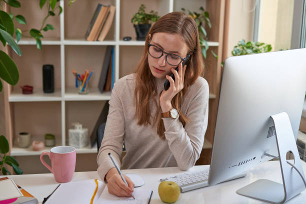 istock Busy lady working at home and using mobile phone 1361614533