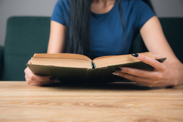 istock A girl reading a book in front of a table 1361618571