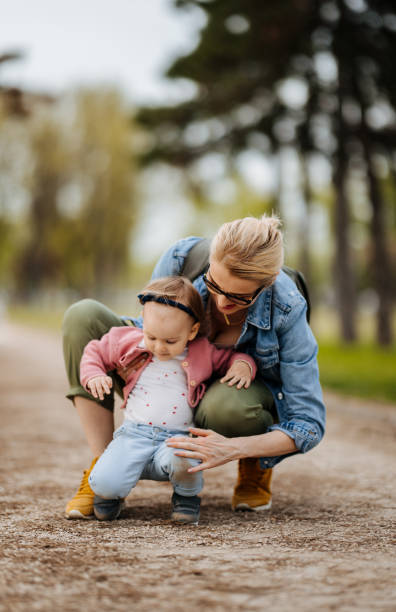 madre e figlia: una passeggiata nel parco - baby first steps autumn child foto e immagini stock