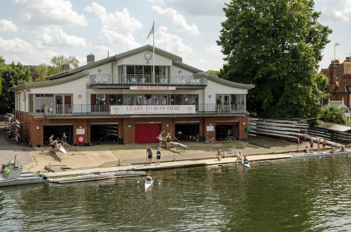 Marlow, UK - July 19, 2021: Students and instructors enjoying lessons on the River Thames at the Marlow Rowing Club on a sunny summer afternoon in Buckinghamshire.