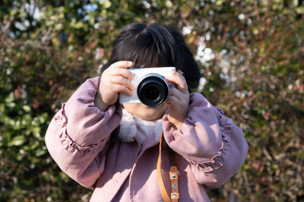 istock Where a little girl is holding a camera 1361629710