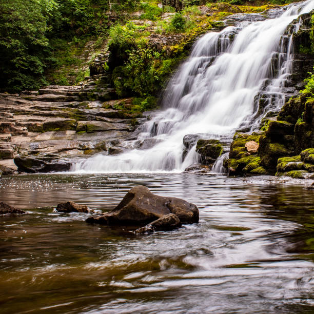 istock Glossy waterfalls with a rock path leading down 1361629949