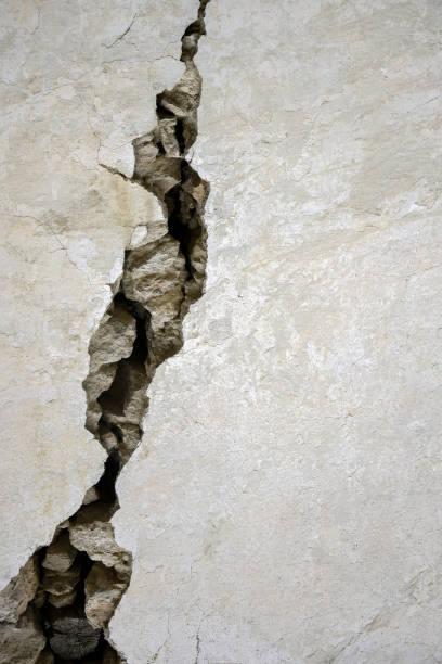 istock Big crack on the gray wall, abstract image of the vertical cleft. 1361631035
