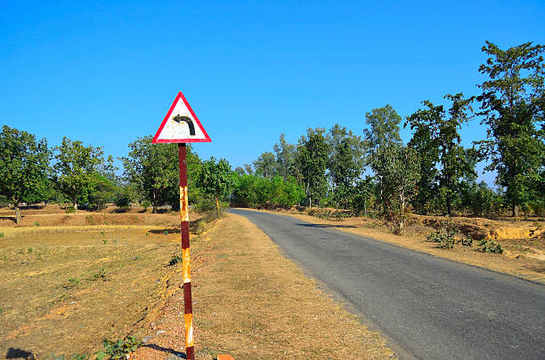 Country road with a turn signboard stock photo