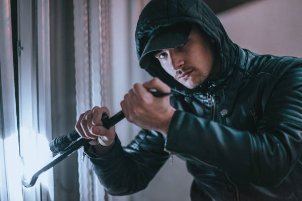 istock A thief trying to get into a house by the backdoor 1361639045