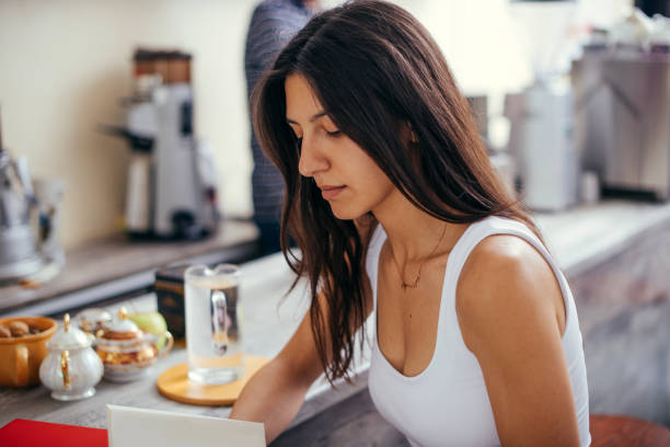 istock Woman reading a book in a coffee shop 1361639897