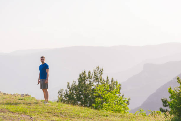 istock A fit male athlete is preparing for a work out in nature while looking over a cliff at the large lake and mountain line. 1361641029