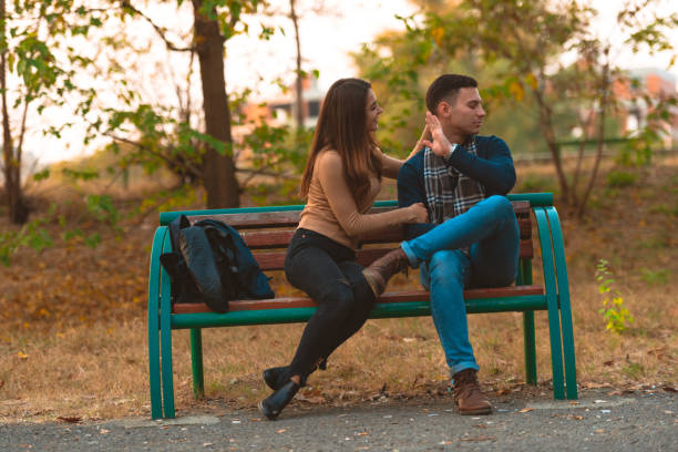 istock Angry boyfriend refusing to talk to his beautiful girlfriend while sitting in a park. 1361641076