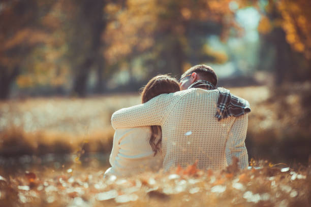 istock Romantic couple hugging and sitting in the park 1361641133