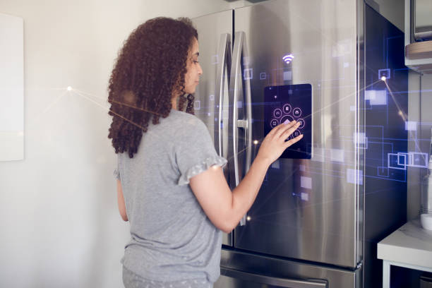 istock Young woman on morning routine checking information from smart fridge 1361654820
