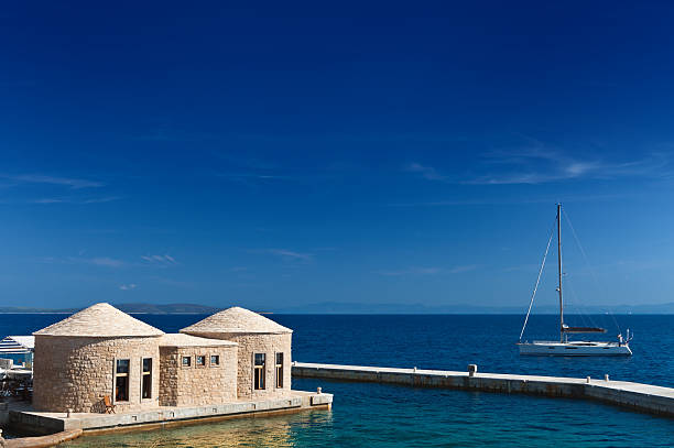 Adriatic coast of Croatia, yacht and traditional huts. Hvar island. stock photo