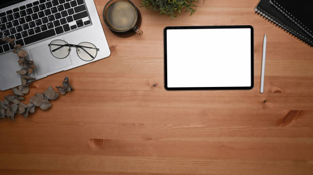 istock Mock up digital tablet, laptop, coffee cup and notebook on Woden background. 1361665382