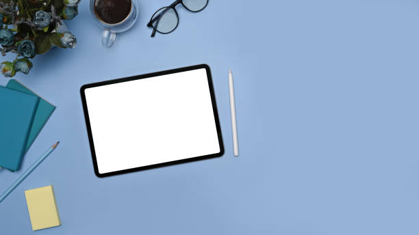 istock Creative workplace with digital tablet, stylus pen and notebook on blue background. 1361665386