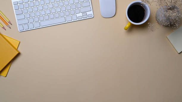 istock Minimal workplace with keyboard, coffee cup and notebook on beige background. 1361665428