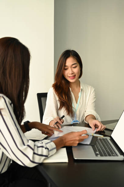 istock Two attractive businesswomen working on project together in modern workplace. 1361666052