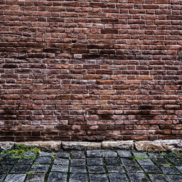 Toned Photo of Old Brick Wall with Cobblestone Road