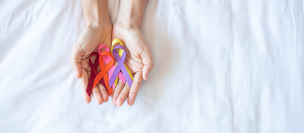 World cancer day (February 4). colorful awareness ribbons; red, orange, purple, pink and yellow color for supporting people living and illness. Healthcare and medical concept