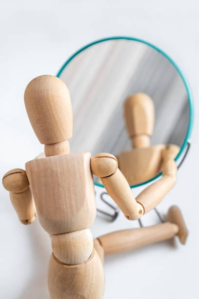 istock Wooden dummy looks at its reflection in the mirror 1361678267