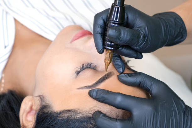 istock Beautician makes permanent eyebrow makeup on the face 1361679133