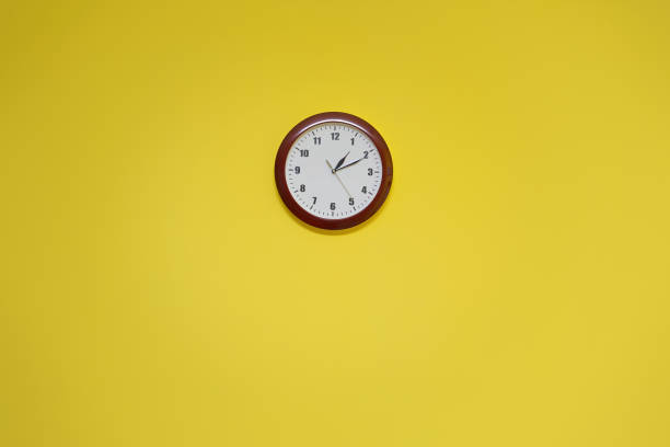 istock Modern round classic watch dial hanging on yellow colored wall 1361680757