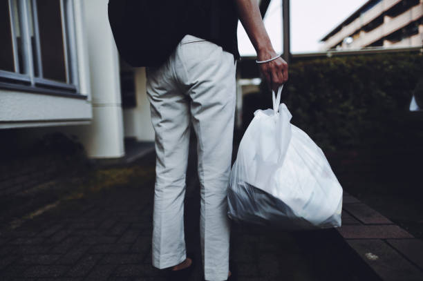 istock Woman holding a trash bag 1361680908