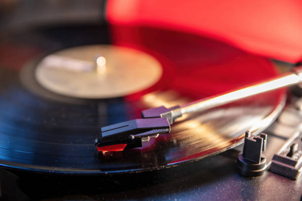 istock Turntable vinyl record player, disco neon light background. Needle on the disc, close up view. 1361682516
