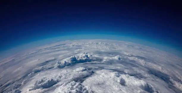 Planet Earth Curvature. Aerial view. Blue sky over heavy cloudscape. Space, science and weather concept
