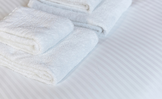 fresh hotel towels with a decorative olive branch and a hat