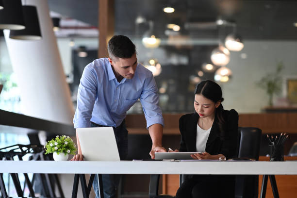 istock Two successful businesspeople working together in modern workplace. 1361683850