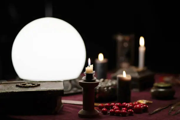 Photo of objects for fortune telling - white ball, candles, book