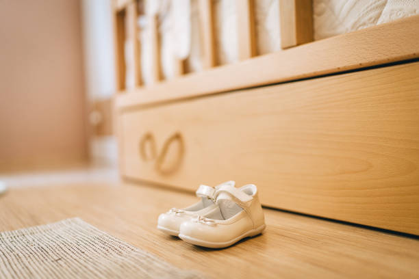 Girls strap shoes on flooring near bed in child room stock photo