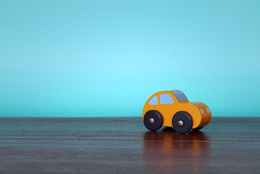 Close up image of wooden toy car with copy space for text. Blue background