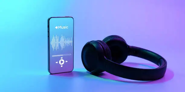 Music background. Mobile smartphone screen with music application, sound headphones. Audio voice with radio beats on neon gradient. Recording studio or podcasting banner with copy space