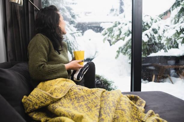 istock Young woman warming with coffee on a winter morning 1361690590