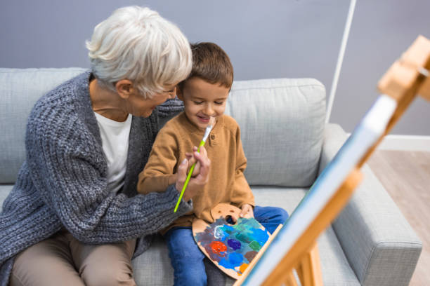 femme âgée avec enfant peignant sur toile. - artist child artists canvas indoors photos et images de collection