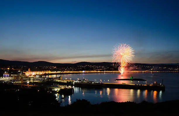 Fireworks at Douglas Bay on the  Isle of Man with reflection on the Irish Sea and Douglas City. View from Douglas Head