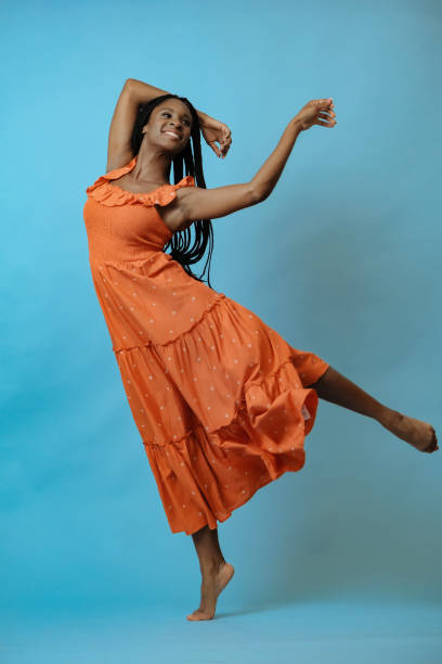 istock black woman smiling and dancing on blue studio background 1361696938
