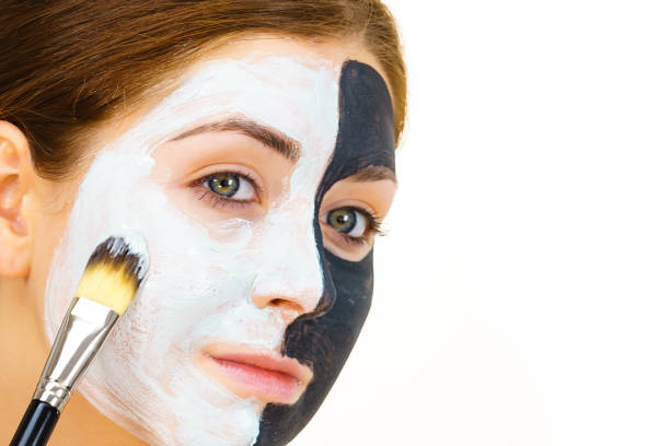 istock Girl black mask on half face apply white mud 1361696999