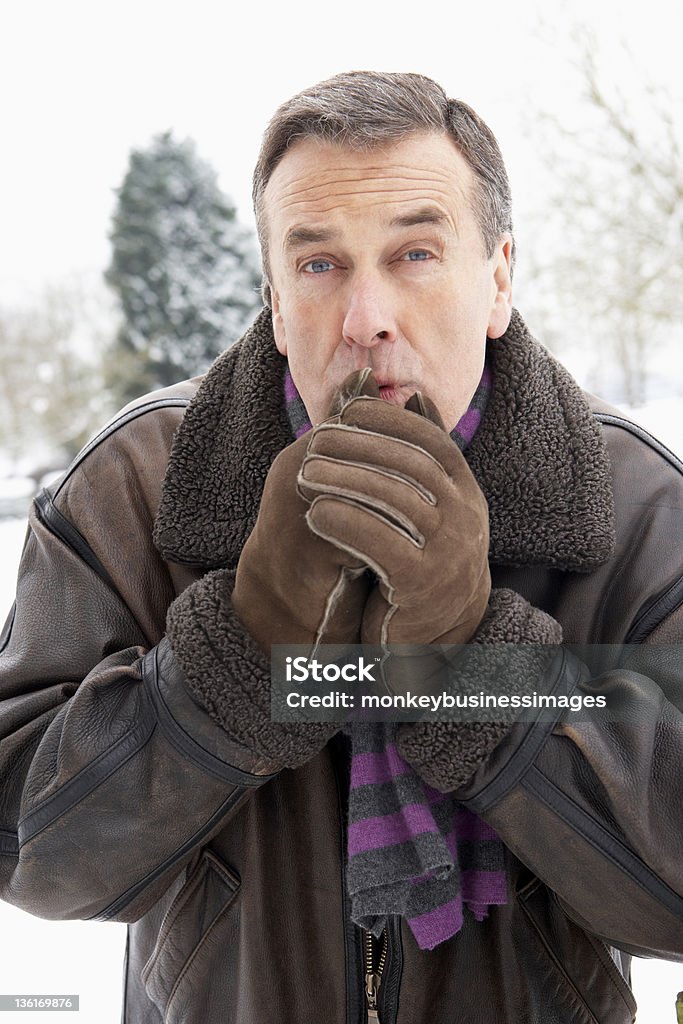 Alter Mann stehen außerhalb In verschneite Landschaft warme Hände - Lizenzfrei 60-69 Jahre Stock-Foto