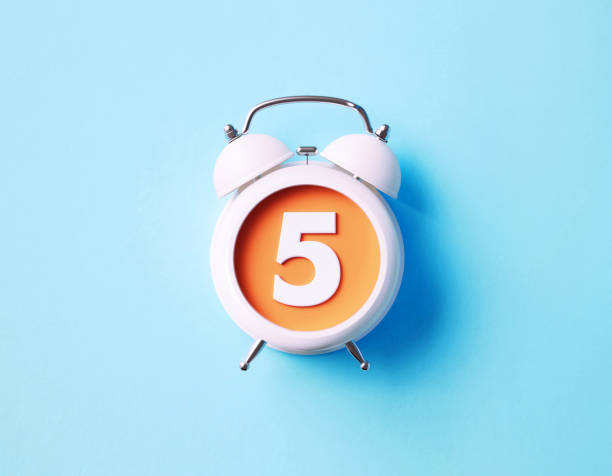 istock Number Five Sitting Over White Alarm Clock On Blue Background 1361700008