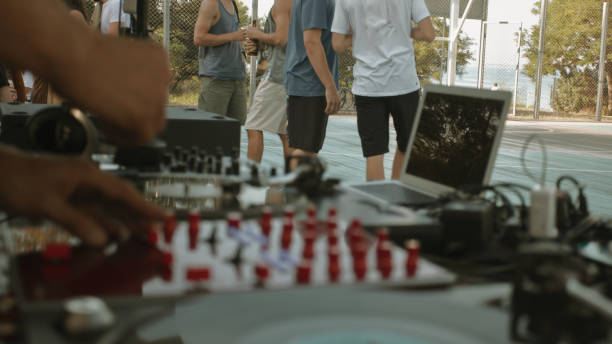 istock Blurred DJ's hands and equipment, focus on people on the background 1361700064