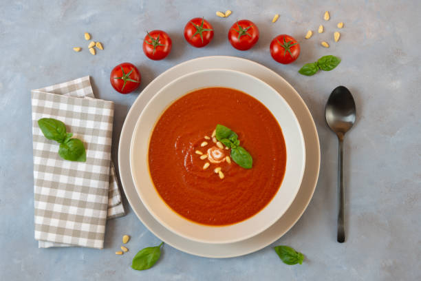 tomatensuppe mit basilikum auf dem teller, hausgemacht und frisch - tomato soup red basil table stock-fotos und bilder