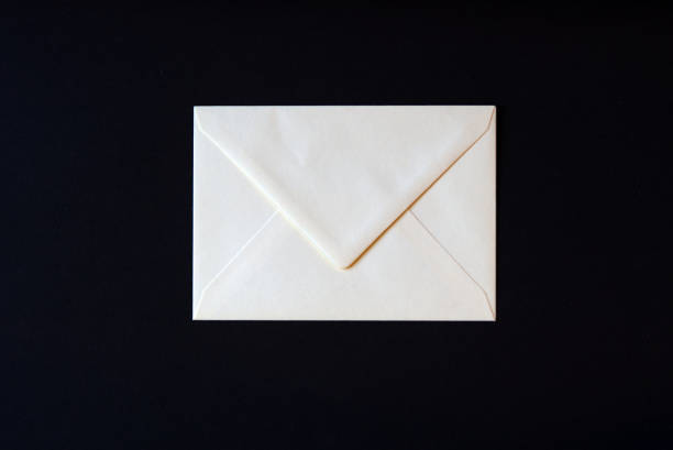 istock Top view of white open envelope against black background. 1361702457