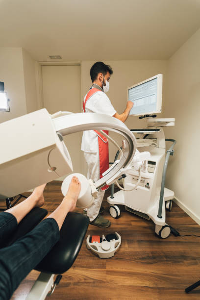 chiropodist doing a diagnose of a foot with an x-ray machine in the medical center - podiatrist podiatry pedicure chiropodist imagens e fotografias de stock