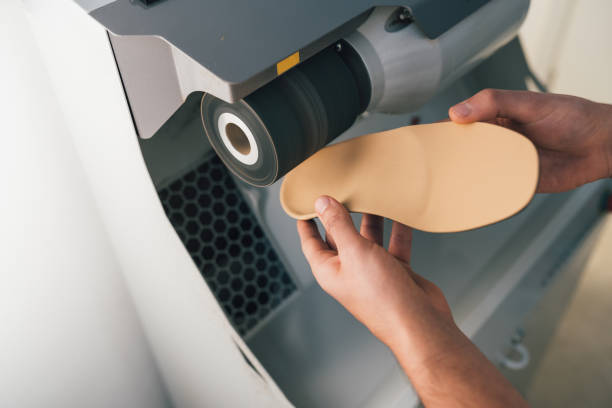 Podiatrist sanding and polishing an orthopedic foot insole for a patient. Podiatrist sanding and polishing an orthopedic foot insole for a patient. sole of shoe stock pictures, royalty-free photos & images