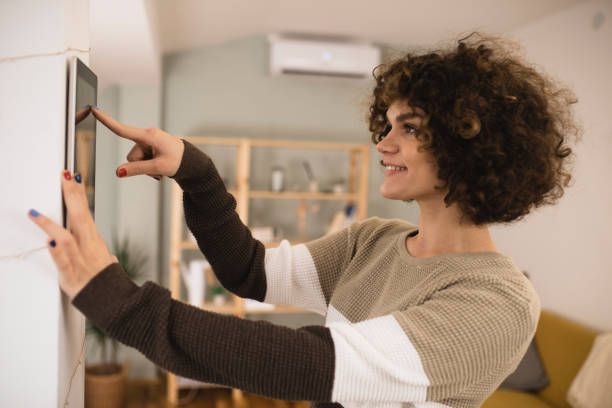 istock Happy young woman adjusting a smart home system using a mobile app 1361705279