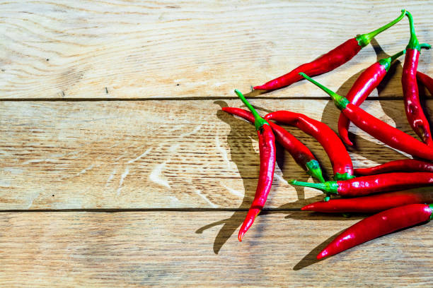 istock Red hot peppers on wooden table 1361705534