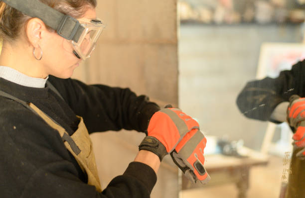 istock Craftswoman adjusting protecting gloves in carpentry workshop 1361706678